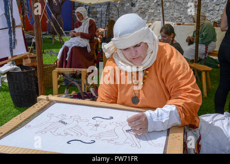 Bellinzona, Switzerland - 27 May 2018: woman who is embroidering at the medieval market on Castelgrande castle at Bellinzona on the Swiss alps Stock Photo