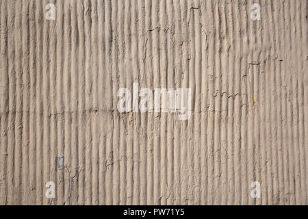 Close up outdoor view of a concrete striped surface. Abstract design of a rough grey texture with shadows. Detail of a modern building wall with rugged elements. Pattern of white and gray lines. Stock Photo