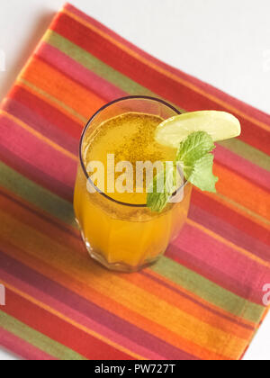 JALJEERA, A SALTY DRINK GARNISHED WITH BUNDIS, LEMON, MINT LEAVES AND ROASTED CUMIN POWDER Stock Photo