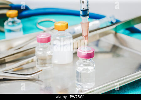 Syringe and medicine vials on doctor work park table close up for healthcare diagnosis concept background Stock Photo