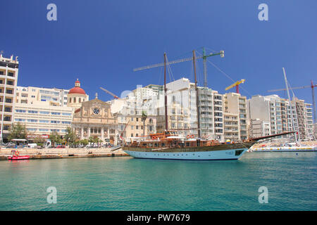 Sliema, Malta - may 2018: Wooden sailboat in Sliema Harbour in sunny day and light blue water Stock Photo