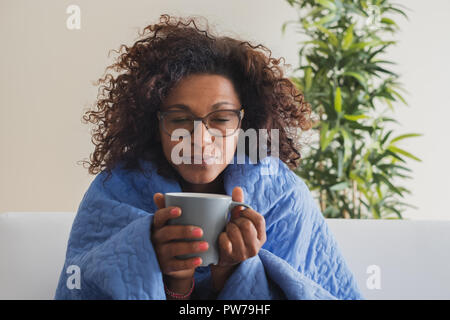 Black woman drinking hot tea and feeling comfortable