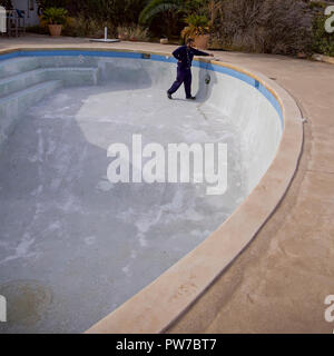 Man working on  repairing lights in a  empty swimming pool. Editorial Image. Stock Photo