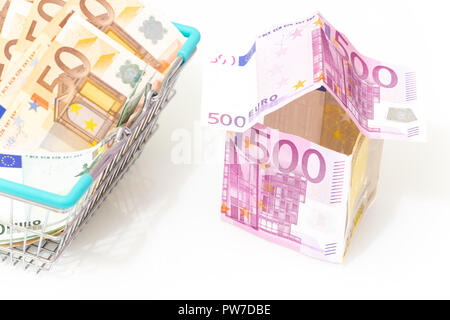euro, the symbol of a housing loan. European money in the shape of a house and a shopping basket with money on a white background Stock Photo