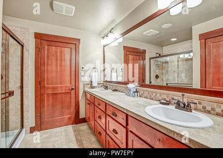 Master bathroom with double sink vanity cabinet and wood framed mirror. Northwest, USA Stock Photo