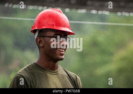 U.S. Marine Jeffrey Decen smiles as it begins to rain on the construction site at Esperanza Elementary School in Casiguran, Aurora, Philippines, Sept. 23, 2017. KAMANDAG has ongoing combined humanitarian and civic assistance activities that enable American and Philippine service members to get to know each other and provide support to local communities. Decen is a fire team leader with Bravo Company, 9th Engineering Support Battalion, 3rd Marine Logistics Group, and is a native of Newark, New Jersey. Stock Photo