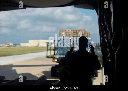 U.S. Air Force Senior Airman Austin Whisler, 21st Airlift Squadron C-17 loadmaster, directs a K-loader in order to load humanitarian aid onto a C-17 Globemaster III aircraft from Travis Air Force Base, Calif., Sept. 22, 2017 at Joint Base San Antonio-Lackland Kelly Field, Texas. The humanitarian aid was delivered to St. Croix, U.S. Virgin Islands after the island had sustained damage from Hurricane Maria. Stock Photo