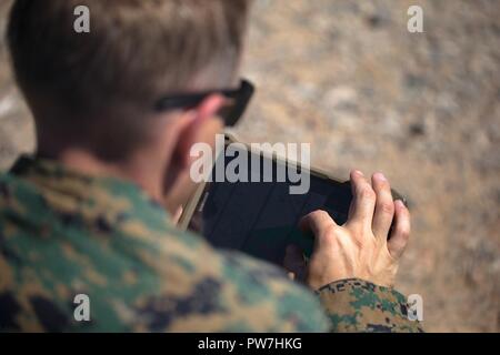 U.S Marine Corps Maj. Eben Buxton, CH-53E instructor with Marine Aviation Weapons and Tactics Squadron One (MAWTS-1) prepares a tablet to provide digitally aided close air support in support of Weapons Tactics Instructors course (WTI) 1-18 at Fire Base Burt, Calif., Sept. 22, 2017. WTI is a seven-week training even hosted by MAWTS-1 cadre, which emphasizes operational integration of the six functions of Marine Corps aviation in support of a Marine Air Ground Task Force and provides standardized advance tactical training and certification of unit instructor qualifications to support Marine avia Stock Photo