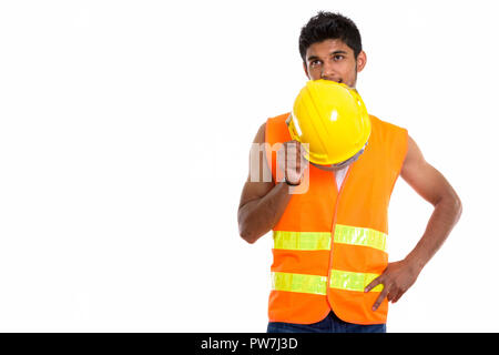 Young handsome Indian man construction worker covering face with Stock Photo