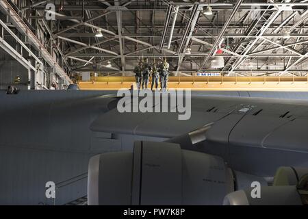 U. S. Air Force Airmen survey the top side of a C-5M Super Galaxy parked inside a hangar for maintenance, Sep. 22, 2017, Travis Air Force Base, Calif. Maintainers from the 660th Aircraft Maintenance Squadron are responsible for the safety and reliability of the fleet, thus strengthening American air power across the globe. Stock Photo