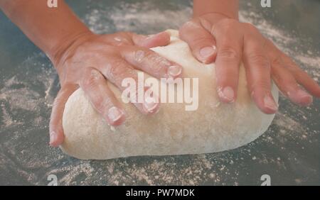 Hands of a woman kneading dough Stock Photo