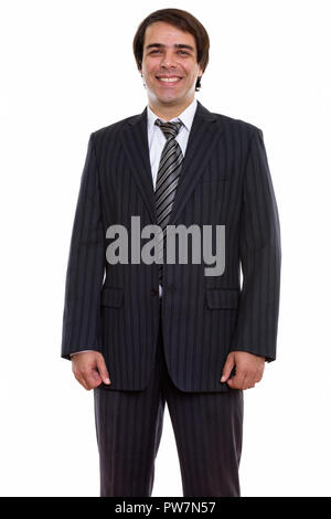 Studio shot of young happy Persian businessman smiling and stand Stock Photo