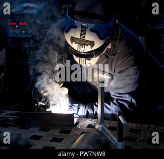 PORTSMOUTH, Va. (Sept. 26, 2017) Hull Maintenance Technician 2nd Class Cullen Kyser, from Youngstown, Ohio., welds in a machinery repair shop aboard the aircraft carrier USS Dwight D. Eisenhower (CVN 69)(Ike). Ike is undergoing a Planned Incremental Availability (PIA) at Norfolk Naval Shipyard during the maintenance phase of the Optimized Fleet Response Plan (OFRP). Stock Photo