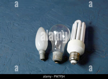Three different shape of electric lamps laid on a painted table, studio closeup Stock Photo
