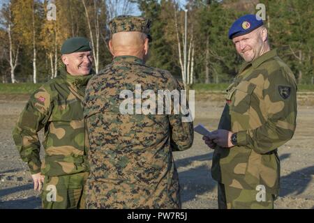 Commandant of the Marine Corps Gen. Robert B. Neller, center, speaks with Norwegian Army Maj. Gen. Odin Johannessen, chief of staff, left, and a Norwegian Army soldier, Setermoen, Norway, Sept. 28, 2017. Neller visited Setermoen to strengthen the military-to-military relationship between the two countries. Stock Photo