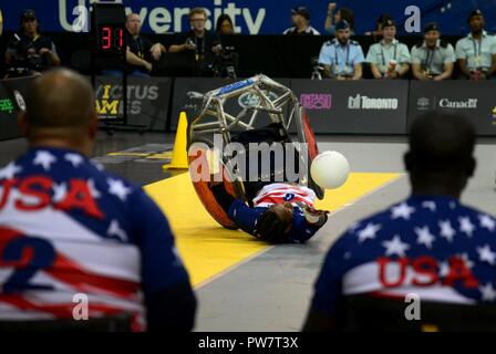 U.S. Marine Corps veteran Anthony McDaniel, a former sergeant and member of Team U.S., takes a fall while still struggling for the ball during wheelchair rugby finals at the 2017 Invictus Games in the Mattamy Athletic Centre in Toronto, Canada, Sept. 28, 2017. The Invictus Games were established by Prince Harry of Wales in 2014, and have brought together more than 550 wounded and injured veterans to take part in 12 adaptive sporting events. Stock Photo