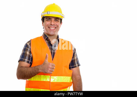 Studio shot of young happy Persian man construction worker smili Stock Photo