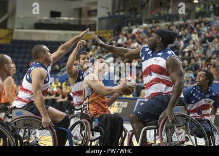 Air Force Master Sgt. Brian Williams, Marine Corps veteran Lance Cpl. Matthew Grashen, Army veteran Spc. Anthony Edward Pone and Marine Corps veteran Sgt. Anthony McDaniel (L to R) look to block Jack Pastora's shot as Team US defeats Netherlands to win the gold medal in Wheelchair Basketball at the Mattamy Centre during the 2017 Invictus Games in Toronto on September 30, 2017. The Invictus Games, established by Prince Harry in 2014, brings together wounded and injured veterans from 17 nations for 12 adaptive sporting events, including track and field, wheelchair basketball, wheelchair rugby, s Stock Photo