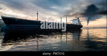 Havana, Cuba. 15th June, 2011. The oil tanker Dart departs from the port early in morning as smoke bellows from the Nico Lopez oil refinery in Havana, Stock Photo