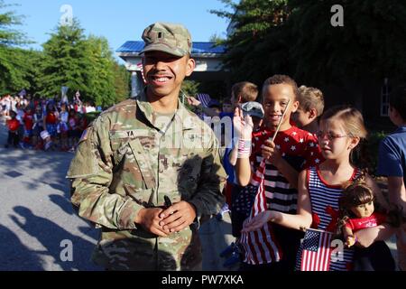 Army 1st Lt. Dan Ya, a Soldier with the 449th Theater Aviation Brigade, laughs with children from the Grace Christian School who lined the street leading up to entrance of the Hope Community Church in Raleigh, N.C. on Sept. 28, 2017 prior to his unit’s deployment ceremony. Over 180 Soldiers and aviators from the 449th and 2-130th will deploy in support Operation Spartan Shield and Operation Inherent Resolve in Kuwait and Iraq. Stock Photo