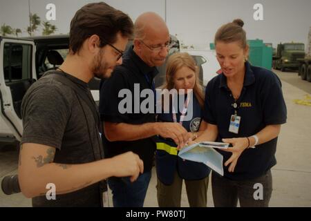 A Federal Emergency Management Agency worker displays a map of Puerto Rico to other employees of different agencies in Puerto Rico Sept. 30, 2017. Stock Photo