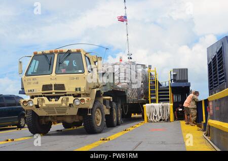 Puerto Rico Army National Guard members ride on a ferry to Culebra Island, Puerto Rico, Oct. 2, 2017, with an M1088 tractor truck loaded with 24 pallets of emergency ration meals. The Federal Emergency Management Agency, the Department of Defense and other government agencies coordinate food and water delivery to civil authorities in Puerto Rico to support disaster relief efforts after Hurricane Maria. Stock Photo