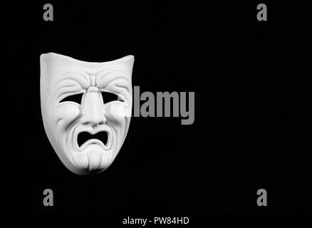 theatre mask expresing the tragedy, white mask on black background with free space for text Stock Photo