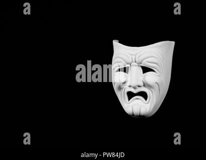 theatre mask expresing the tragedy, white mask on black background with free space for text Stock Photo