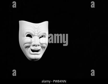 theatre mask expresing the comedy, white mask on black background with free space for text Stock Photo