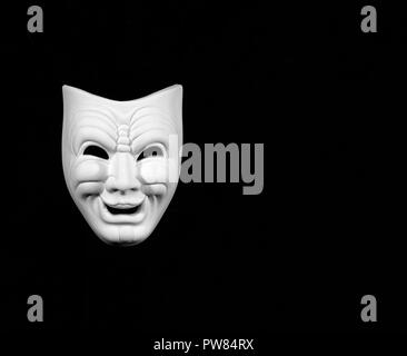 theatre mask expresing the comedy, white mask on black background with free space for text Stock Photo