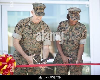 U.S. Marine Corps Brig. Gen. William J. Bowers, president of Marine Corps University, left, and Sgt. Maj. Robin C. Fortner, director of the Staff Non-Commissioned Officer Academy, cut the ribbon during the ribbon cutting ceremony at Camp Johnson N.C., Oct. 3, 2017. The purpose of the ribbon cutting ceremony was to introduce the Marine Corps University's newest addition to the professional military education platform. Stock Photo