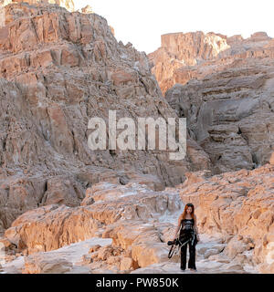 Lady with camera walking in  White Canyon. South Sinai. Egypt Stock Photo