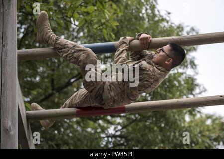 CAMP HOVEY, Republic of Korea: Spc. Juan Villegas (1st Battalion, 8th Cavalry Regiment, 2nd Armored Brigade Combat Team, 1st Cavalry Division) climbs up and over an obstacle during the Eight Army Best Medic Competition on September 27, 2017. Soldiers in two-man teams competed against each other during several events on the course of two days. The winning team will go on to represent Eighth Army in the Army Best Medic Competition October 27 through November 2, 2017 at Camp Bullis, Texas. Stock Photo