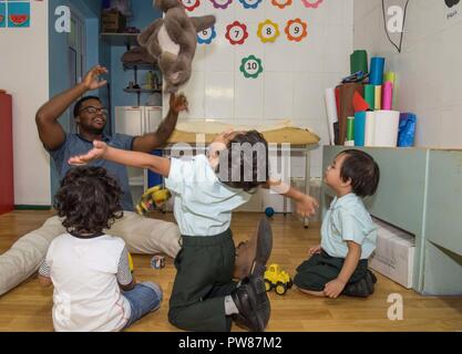 MANAMA, Bahrain (Sept. 28, 2017) Sonar Technician (Surface) 2nd Class Maurice Robins, from Baton Rouge, La., assigned to the Ticonderoga-class guided-missile cruiser USS Princeton (CG 59), plays with students at the Regional Institute for Active Learning School in Bahrain during a volunteer service project. Princeton is deployed in the U.S. 5th Fleet area of operations in support of maritime security operations designed to reassure allies and partners, and preserve the freedom of navigation and the free flow of commerce in the region. Stock Photo