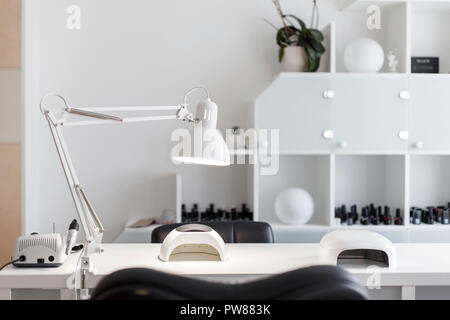 Interior studio for nail care. White room for manicure with a lamp and a tool Stock Photo