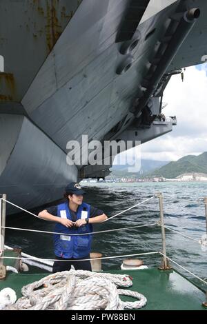 US Navy Deck Seaman looks through handouts with his son during a pre ...