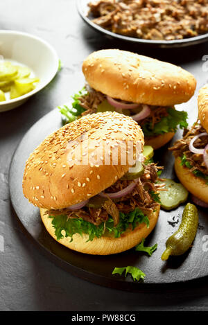 Pulled beef sandwiches with vegetables on black wooden board Stock Photo