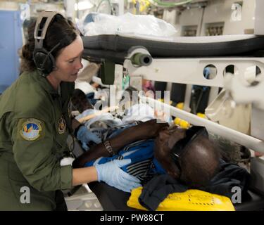 U.S. Air Force Master Sgt. Mary-Beth Young, assigned to the 45th Aeromedical Evacuation Squadron, tends to patients aboard a C-17 Globemaster III while enroute from St. Croix to Dobbins Air Reserve Base, Ga., Sept. 24, 2017. Reserve Citizen Airmen conduct humanitarian mission to St. Croix to evacuate victims affected by Hurricane Maria. Stock Photo