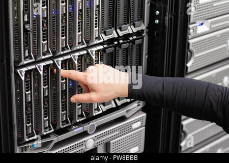 Male IT Engineer Installing Blade Server In SAN At Datacenter Stock Photo