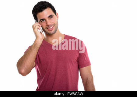 Studio shot of young happy handsome Hispanic man smiling while t Stock Photo