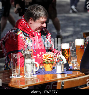 Bayern Munich football supporter quietly enjoying a beer in Munich centre market prior to the game. Stock Photo