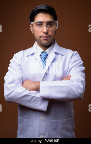 Young handsome Iranian man doctor wearing protective glasses aga Stock Photo
