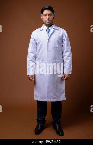 Young handsome Iranian man doctor wearing protective glasses aga Stock Photo