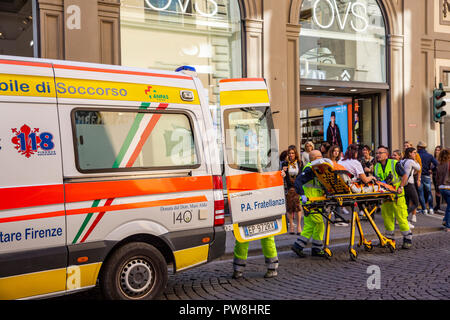 Injured lady being helped into an Italian ambulance by health staff paramedics in Florence,Tuscany,Italy Stock Photo