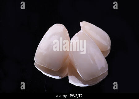 dental ceramic veneers and crowns isolated with mirror background. Stock Photo