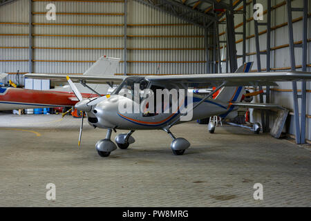 outdoor shot of small plane standing in shed Stock Photo