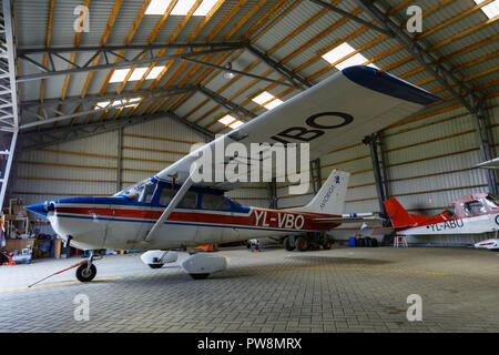 outdoor shot of small plane standing in shed Stock Photo