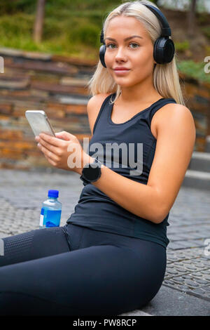 Sporty Young Woman Listening Music With Headphones And Smartphon Stock Photo