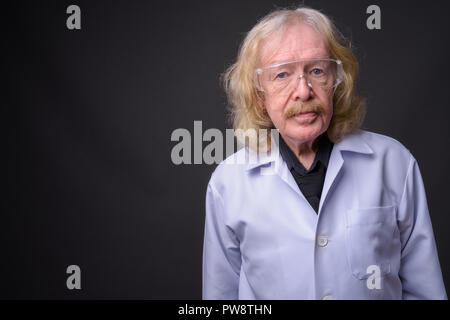 Senior man doctor with mustache wearing protective glasses again Stock Photo