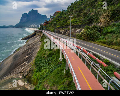 Highway by the sea. Wonderful road and bike path. Bicycle and road track and next to the blue sea in the city of Rio de Janeiro. Tim Maia bike path.